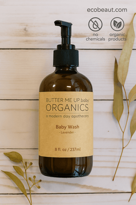 Butter Me Up Baby Organics baby wash bottle on a wooden background with leaves.