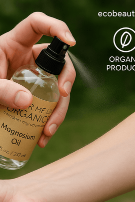 A hand spraying Butter Me Up Organics Magnesium Oil onto a forearm outdoors, with eco labels “no chemicals,” “organic products,” and the website ecobeaut.com in the top right corner.