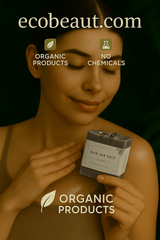 A photograph of a young woman gently holding a bar of "Blue Sea Salt Amor" handmade soap against her shoulder, with a serene smile, surrounded by green foliage and branding elements like "ecobeaut.com", "Organic Products", and "No Chemicals" in the upper right corner.