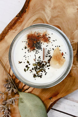 Candle in a glass jar with decorative elements on a wooden board