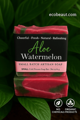 Aloe Watermelon artisan soap with pink and green swirls placed among lush leaves, featuring the site name ecobeaut.com in the upper right corner and eco labels 'NO CHEMICALS' and 'ORGANIC PRODUCTS' at the bottom of the image.