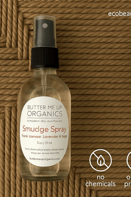 Butter Me Up Organics Smudge Spray bottle on a woven mat background with a succulent, eco labels “no chemicals” and “organic products,” and ecobeaut.com displayed in the top right corner.
