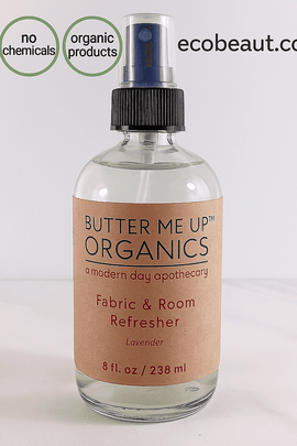 Butter Me Up Organics lavender fabric and room refresher spray bottle displayed on a marble surface with fresh lavender – natural home scent product made in the USA