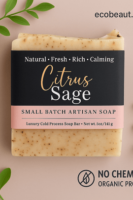 Citrus Sage artisan soap with a blush and black label, placed on a soft mauve background surrounded by green leaves. ecobeaut.com appears in the top right, and eco-labels 'NO CHEMICALS' and 'ORGANIC PRODUCTS' are clearly displayed at the bottom.
