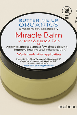 Close-up of Butter Me Up Organics Miracle Balm in a transparent jar with black lid – labeled for joint and muscle pain, with no chemicals and organic ingredients, ecobeaut.com