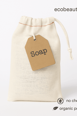 Close-up of muslin drawstring soap bag with kraft label – organic bath tea, no chemicals, eco-friendly, minimalist white background