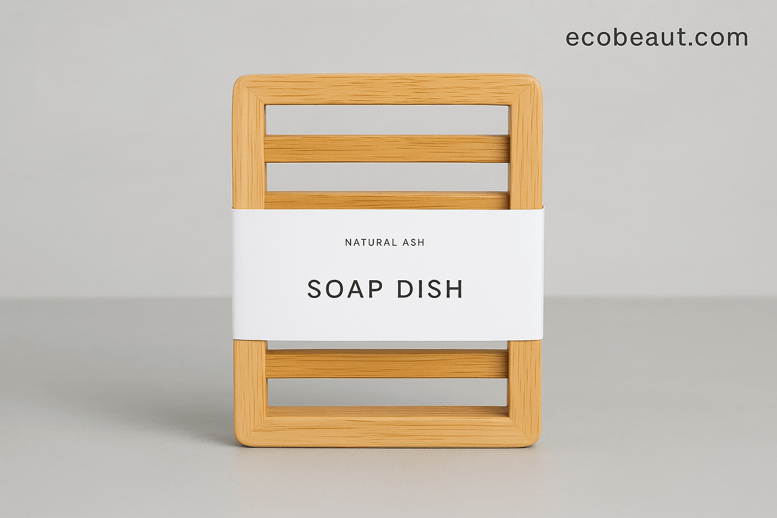 Close-up of natural ash wood soap dish with white minimalist label on light gray background – ecobeaut.com