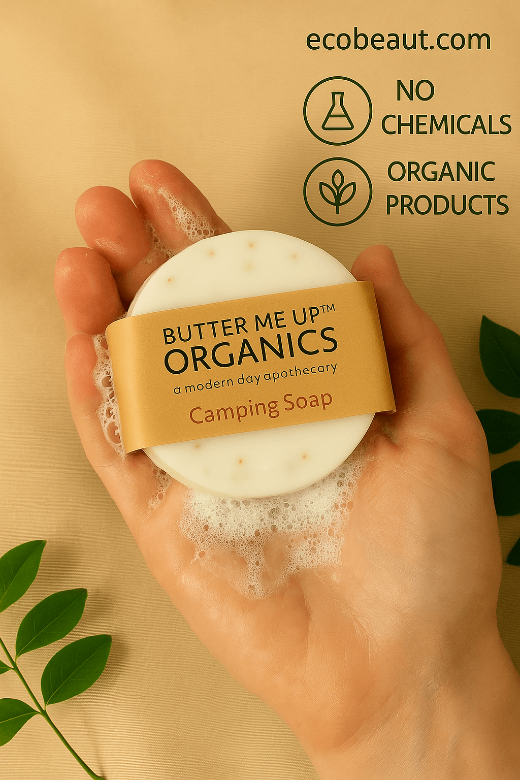 Fair-skinned hand holding Butter Me Up Organics Camping Soap from ecobeaut.com with foamy lather, green leaves, and eco-friendly icons in the top right corner.