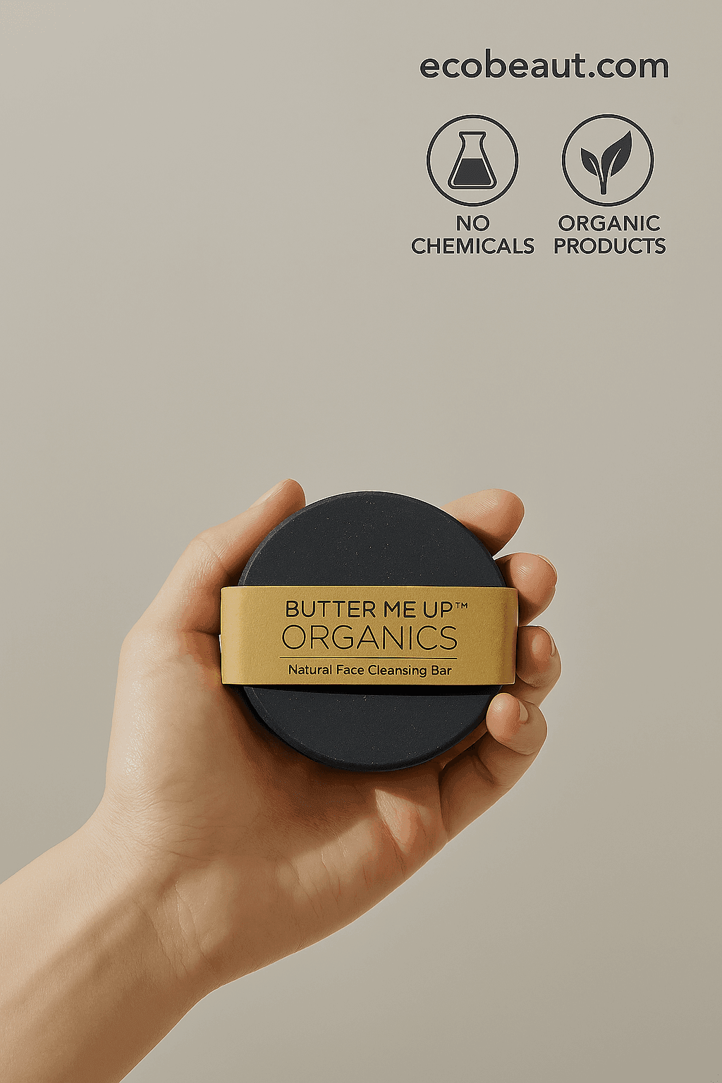 Fair-skinned hand holding a round Butter Me Up Organics soap bar from ecobeaut.com, with “NO CHEMICALS” and “ORGANIC PRODUCTS” icons in the top right corner.