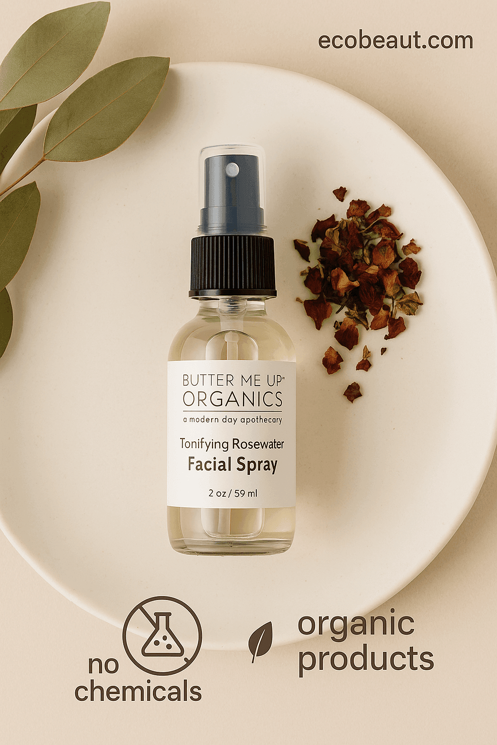 Glass bottle of Butter Me Up Organics Tonifying Rosewater Facial Spray placed on a cream-colored ceramic plate with dried rose petals and eucalyptus leaves, featuring eco-friendly labels "no chemicals" and "organic products" below, and "ecobeaut.com" in the top right corner.