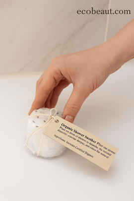 Hand holding lavender organic shower steamer under running water – relaxing aromatherapy shower moment by ecobeaut.com