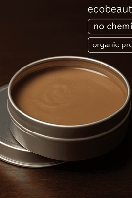 Open metal tin of brown balm on dark wooden surface with eco labels and ecobeaut.com in the upper right corner.