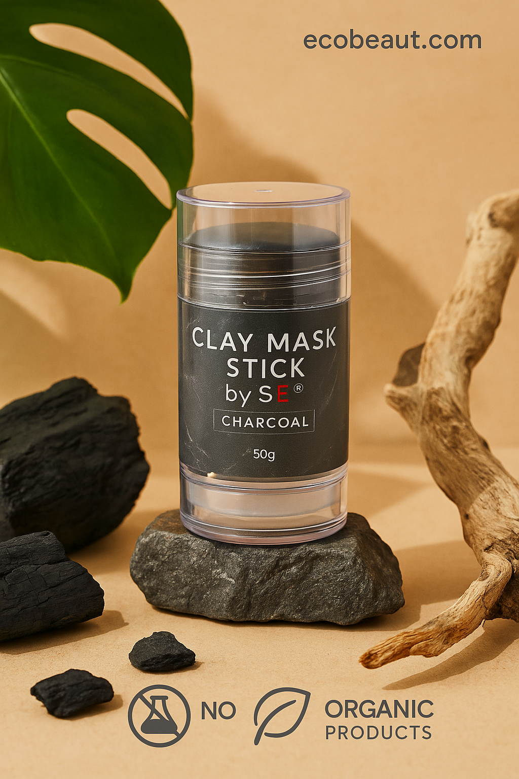 "SE Charcoal Clay Mask Stick displayed on a beige surface surrounded by natural elements like stones, charcoal, driftwood, and a monstera leaf, with ecobeaut.com in the top right corner and label NO CHEMICALS at the bottom