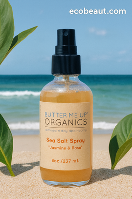 Butter Me Up Organics Sea Salt Spray bottle on a beach with ocean view