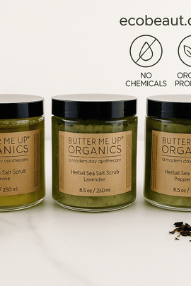"Three jars of herbal sea salt scrubs with eco labels and ecobeaut.com branding above, set against a white background with natural botanicals."