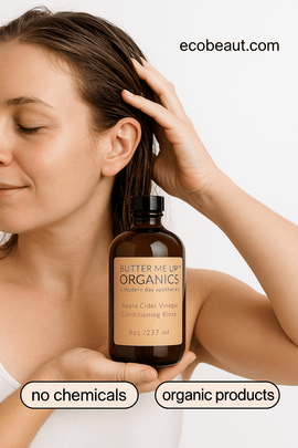 Woman applying Butter Me Up Organics Conditioning Rinse to wet hair, holding the bottle, with “no chemicals,” “organic products” labels below and ecobeaut.com in the top right corner.