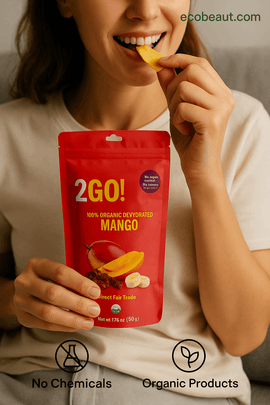 Woman enjoying 2GO! Organic Dried Fruit Snacks – Real-life use of 100% organic and chemical-free dried banana, mango, pineapple, and golden berries. Perfect healthy snacking, with ecoBeaut.com logo shown.