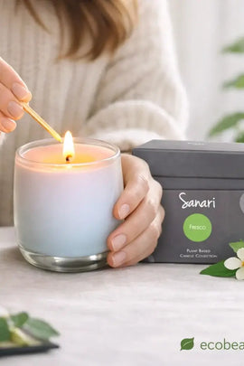 Person lighting a candle with a Sanari branded box in the background