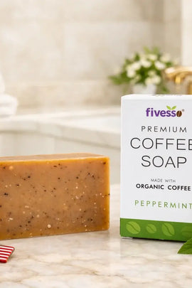 Fivess coffee soap bar and packaging on a bathroom counter with flowers and an American flag keychain.