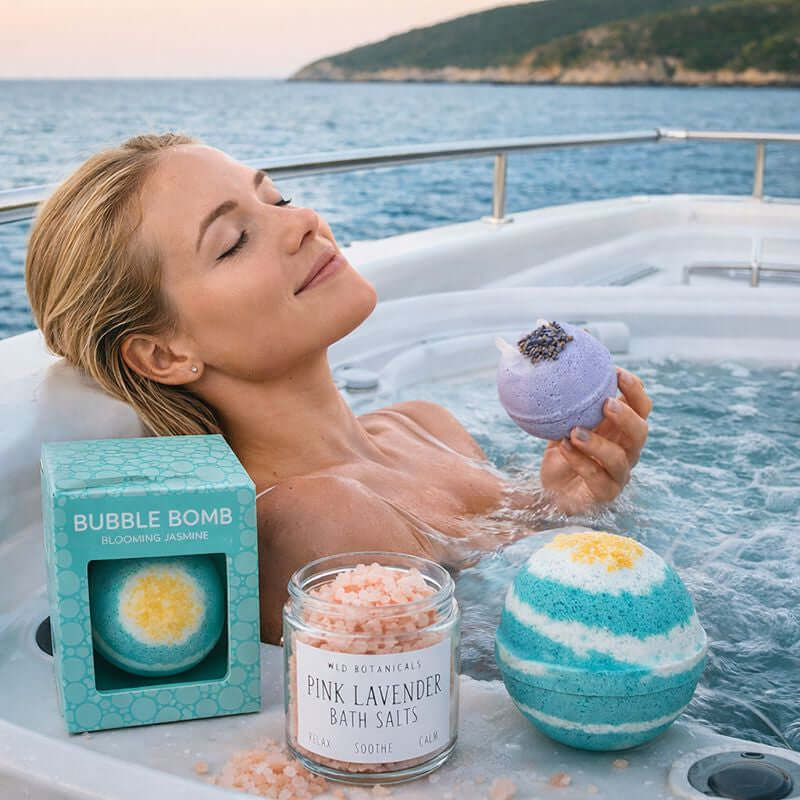 Blonde woman relaxing in a yacht jacuzzi at sunset, holding a lavender bath bomb beside organic bath salts and bubble bombs, showcasing eco-friendly bath products from ecobeaut.com.