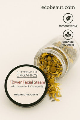 A close-up image of Butter Me Up Organics Flower Facial Steam with Lavender & Chamomile. The product jar is spilling dried flowers like chamomile and lavender onto a neutral beige background. The top right corner displays the website ecobeaut.com along with clean icons for “no chemicals” and “organic products,” highlighting the product’s natural ingredients.








