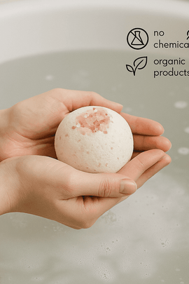 Hand holding a bath bomb with 'no chemicals, organic products' text and icons.