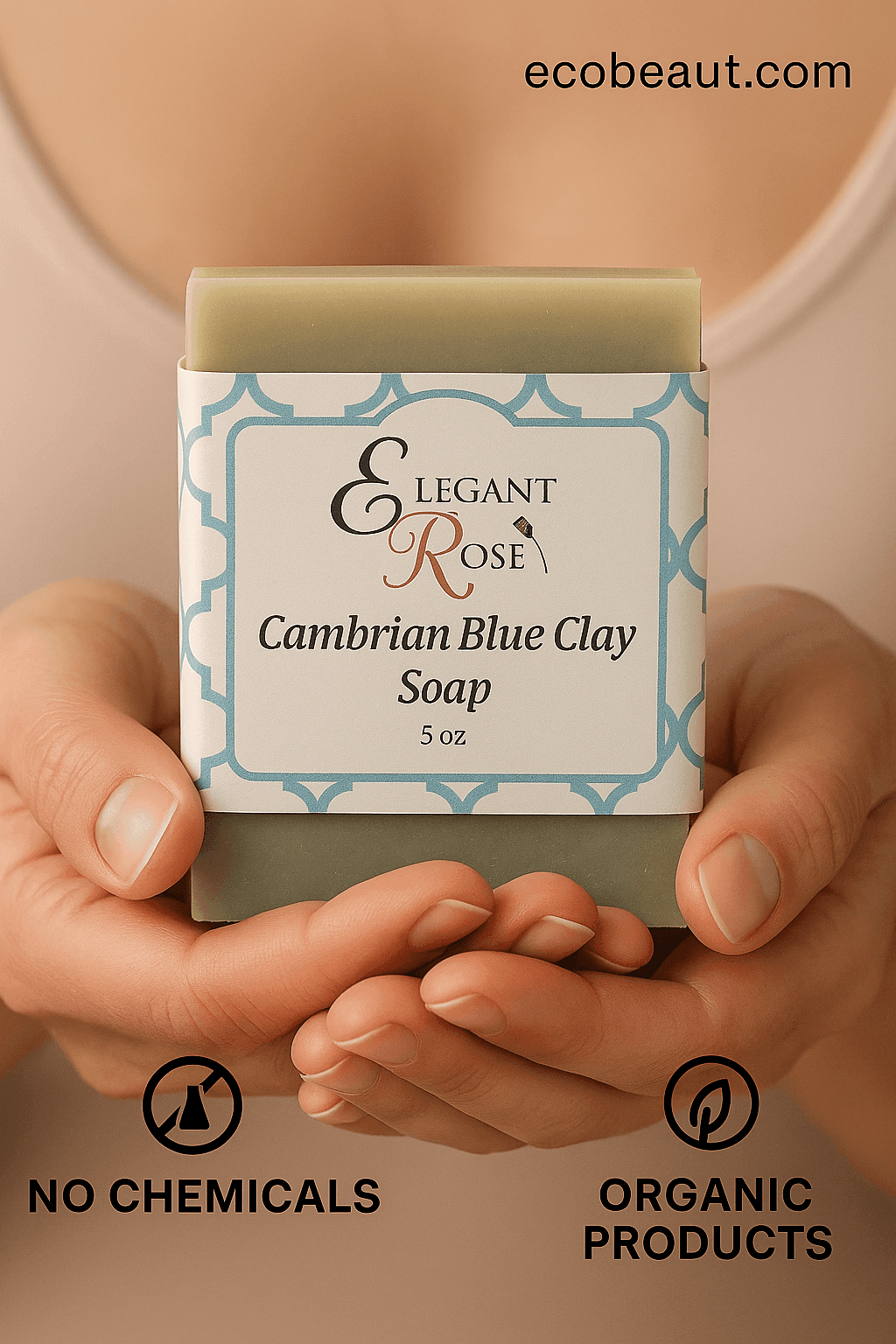 A person gently holds a Cambrian Blue Clay Soap bar from Elegant Rose with both hands. 'ecobeaut.com' appears in the top right corner, and eco icons 'NO CHEMICALS' and 'ORGANIC PRODUCTS' are shown at the bottom.