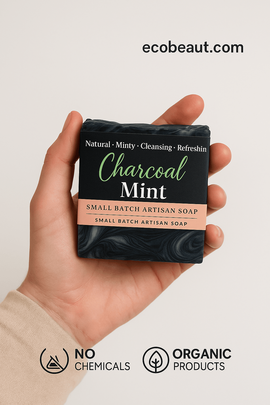 A person holds a Charcoal Mint artisan soap bar with black and green swirls. The label highlights natural ingredients. 'ecobeaut.com' is in the top right, with 'NO CHEMICALS' and 'ORGANIC PRODUCTS' icons at the bottom.