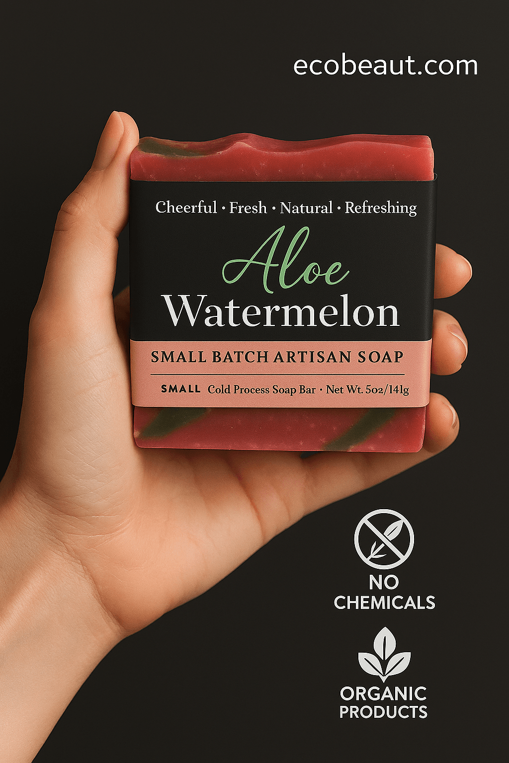 A person holds a bar of Aloe Watermelon artisan soap from ecobeaut.com in their hand. The soap is marbled in pink and green with a black label, and eco-labels 'NO CHEMICALS' and 'ORGANIC PRODUCTS' are displayed below on a dark background.