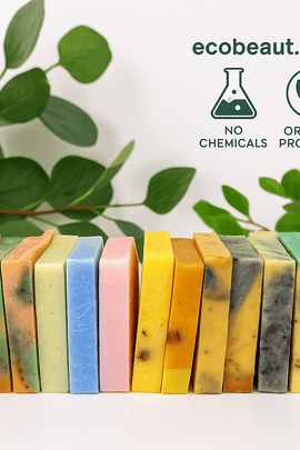 A row of twelve colorful handmade soap bars by ecobeaut.com with green leaves in the background and “NO CHEMICALS” and “ORGANIC PRODUCTS” icons in the upper right corner.




