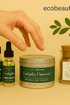 A woman's hand reaching for a eucalyptus and spearmint soy candle among natural spa products, with green leaves and ecobeaut.com displayed in the top right corner.






