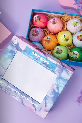 Colorful bath bombs in a box with a decorative card on a purple background