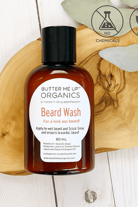 Butter Me Up Organics Beard Wash bottle on wooden tray with eucalyptus leaves – no chemicals, organic grooming product from ecobeaut.com
