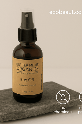 Butter Me Up Organics Bug Off spray bottle placed on a flat stone slab with a beige background, featuring “no chemicals,” “organic products” icons and ecobeaut.com in the top right corner.




