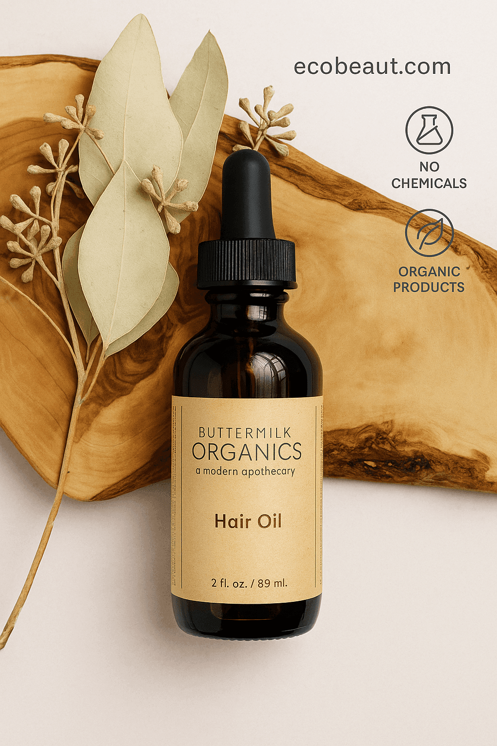 Butter Me Up Organics Hair Oil bottle on wood with beige label, next to dried leaves and ecobeaut.com branding.