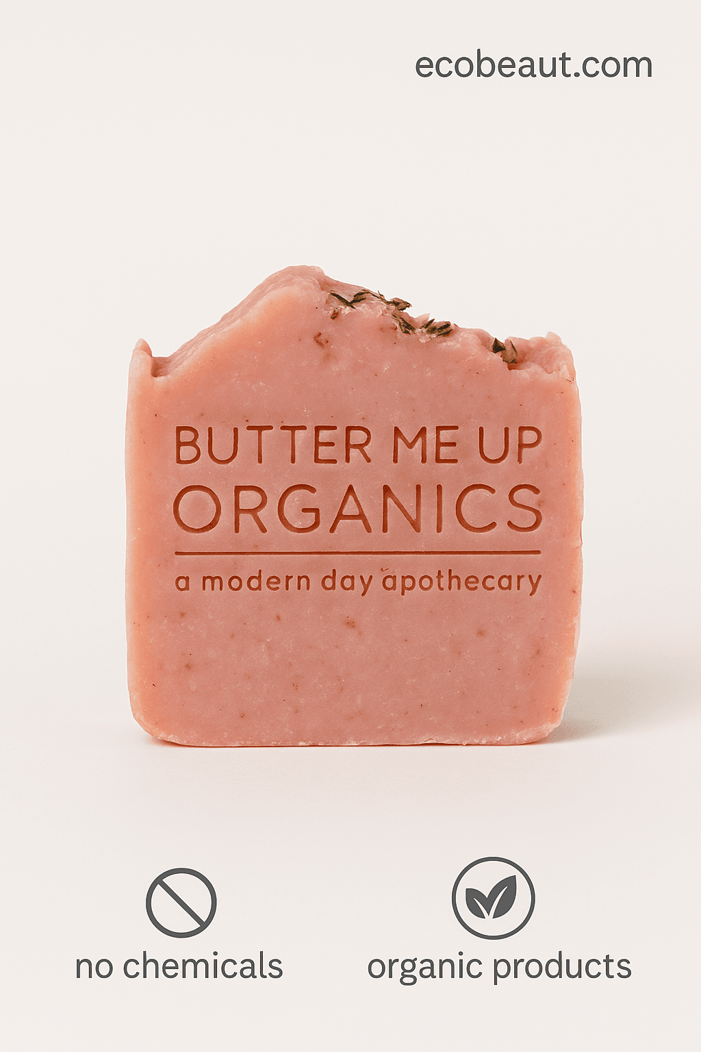 Butter Me Up Organics pink soap with herbal topping displayed on marble dish surrounded by green plants and crystals, featuring ecobeaut.com – organic handmade soap USA