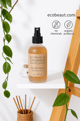 Butter Me Up Organics sea salt spray on a white shelf with plants, eco-friendly icons, and ecobeaut.com branding.