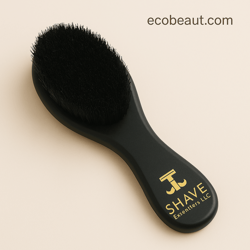 Close-up of premium black boar bristle beard brush by SHAVE Essentials LLC with gold logo, shown on a soft neutral background — ecobeaut.com