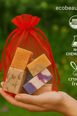 Colorful 1 LB handmade soap gift samples in a red mesh bag, displayed flat with decorative green leaves – ecobeaut.com