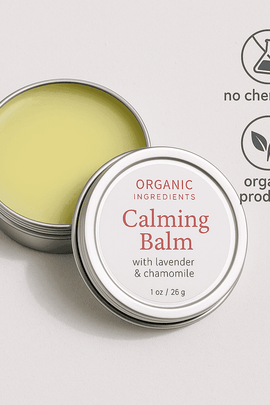 Dream Balm aromatherapy sleep aid with organic ingredients – calming balm surrounded by crystals, incense, and green plants on a white surface from ecobeaut.com