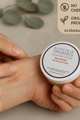 Fair-skinned person applies organic scar serum with Manuka honey onto their wrist while holding the product jar; labels "no chemicals" and "organic products" with ecobeaut.com appear in the upper right corner.







