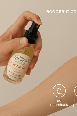 Hand spraying Butter Me Up Organics Smudge Spray onto a forearm with a soft beige background, featuring “no chemicals,” “organic products” icons and ecobeaut.com in the top right corner.