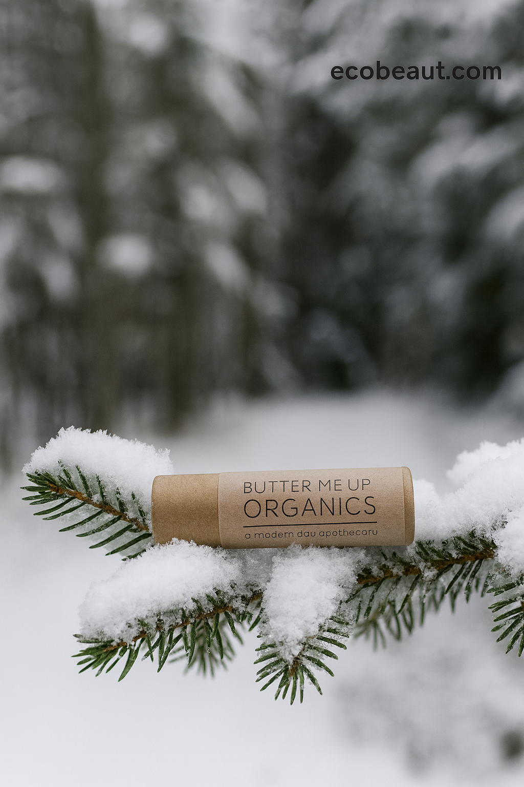 Butter Me Up Organics product on a snow-covered branch with a blurred forest background