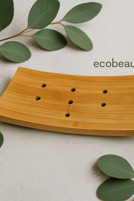 "Natural bamboo soap dish with drainage holes surrounded by eucalyptus leaves – eco-friendly bathroom accessory from ecobeaut.com