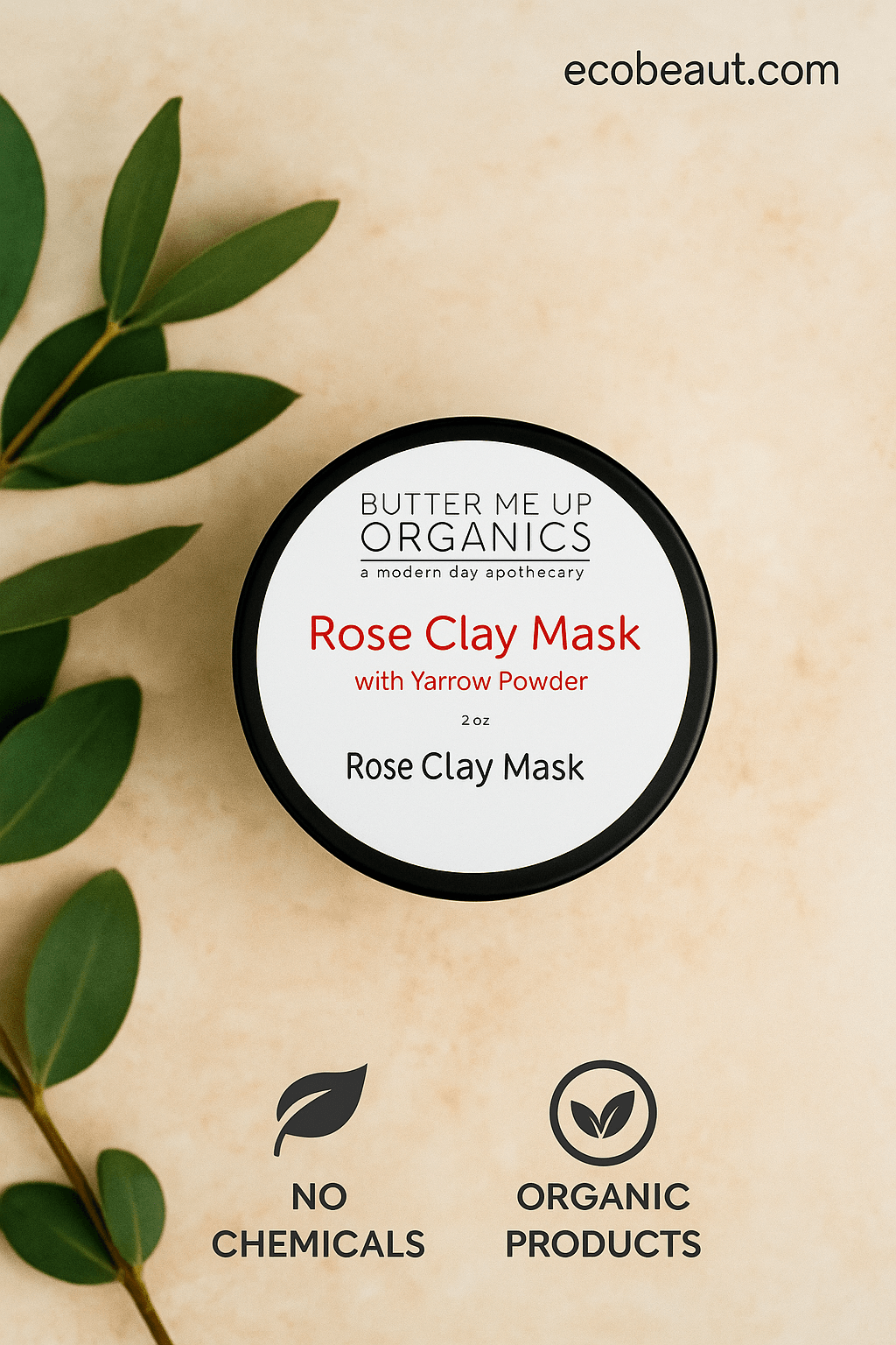 Open jar of Butter Me Up Organics Rose Clay Mask placed on a neutral surface, with black lid beside it, surrounded by green leaves, 'no chemicals' and 'organic products' icons at the bottom, and ecobeaut.com displayed in the top right corner