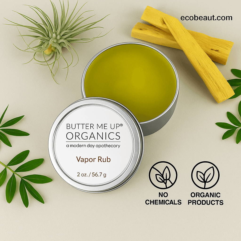 "Open tin of Butter Me Up Organics Vapor Rub with green balm, surrounded by palo santo sticks and leaves, eco labels, and ecobeaut.com branding in the top right corner."