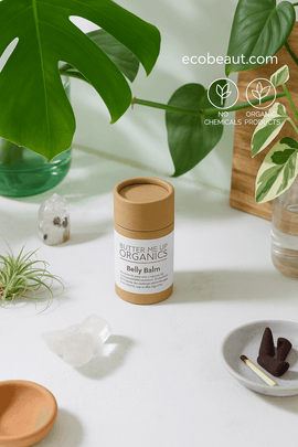 "Organic Belly Balm in kraft tube on white surface with green plants, eco labels, and ecobeaut.com branding in the corner."






