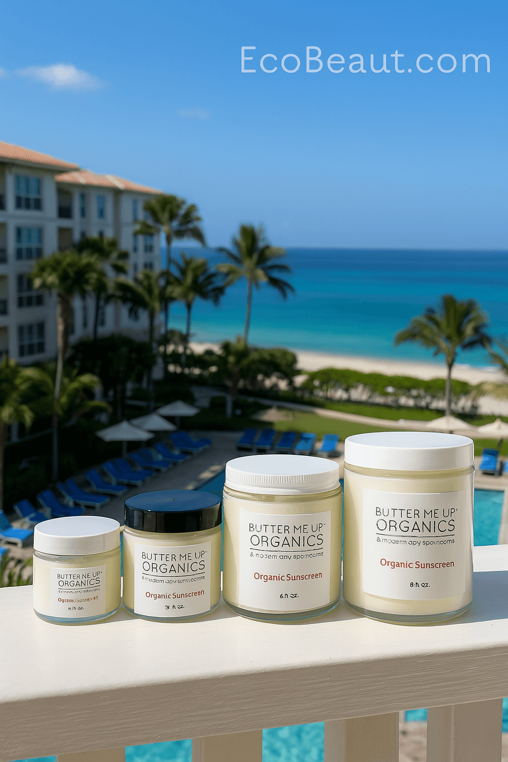 Butter Me Up Organics sunscreen collection displayed on balcony of luxury American oceanfront hotel, eco-friendly organic sunscreen jars with palm trees, beach, and blue ocean in background, branded EcoBeaut.com