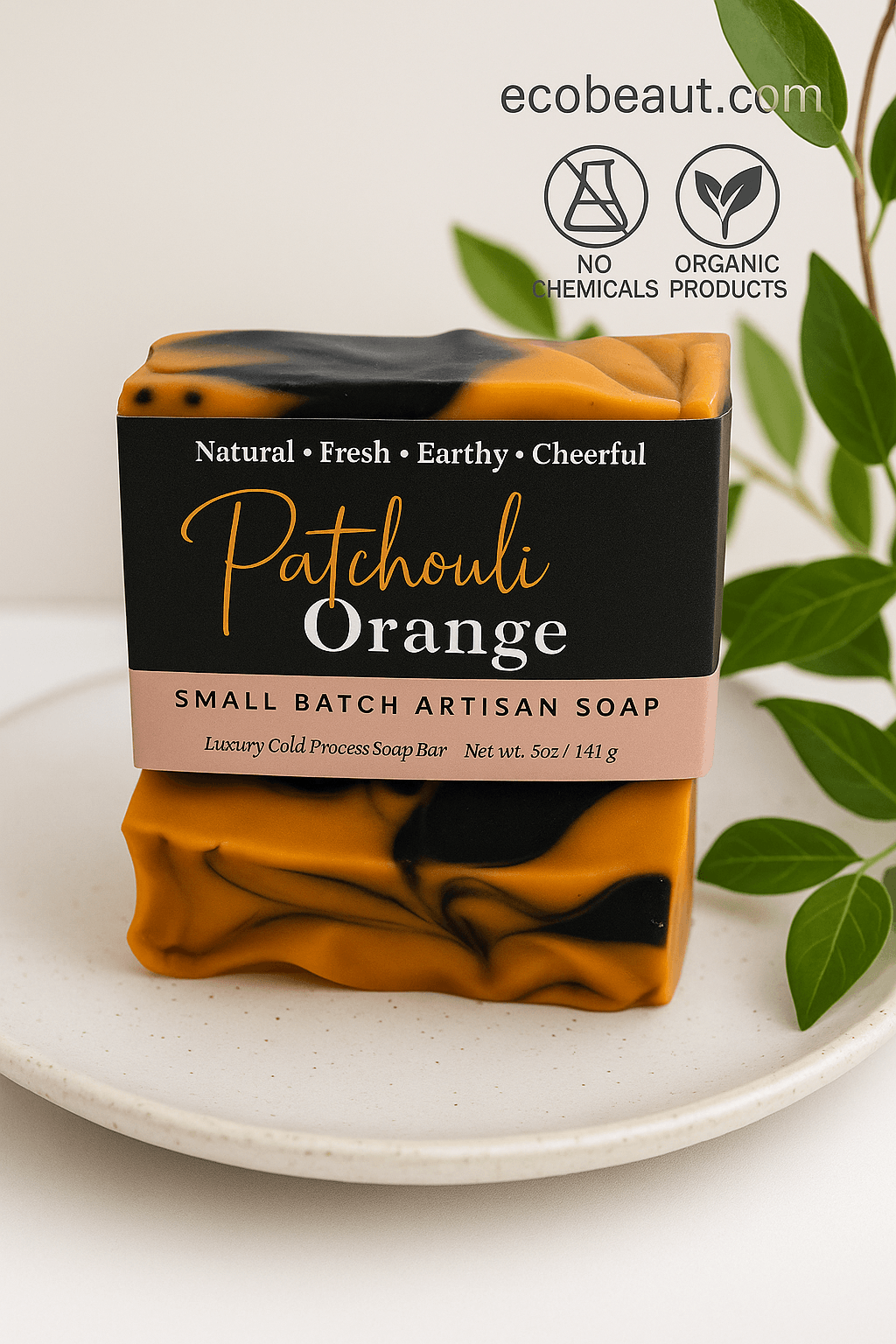 Patchouli Orange artisan soap bar by ecobeaut.com surrounded by fresh green leaves, with “NO CHEMICALS” and “ORGANIC PRODUCTS” icons in the top right corner.
