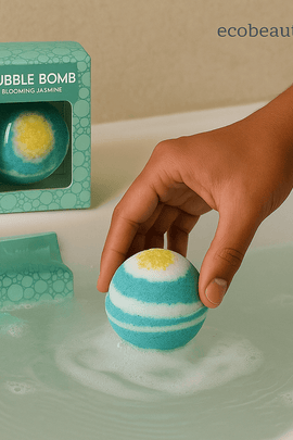 Person dropping Blooming Jasmine Bubble Bomb into a bathtub, creating bubbles, with product box nearby, ecobeaut.com
